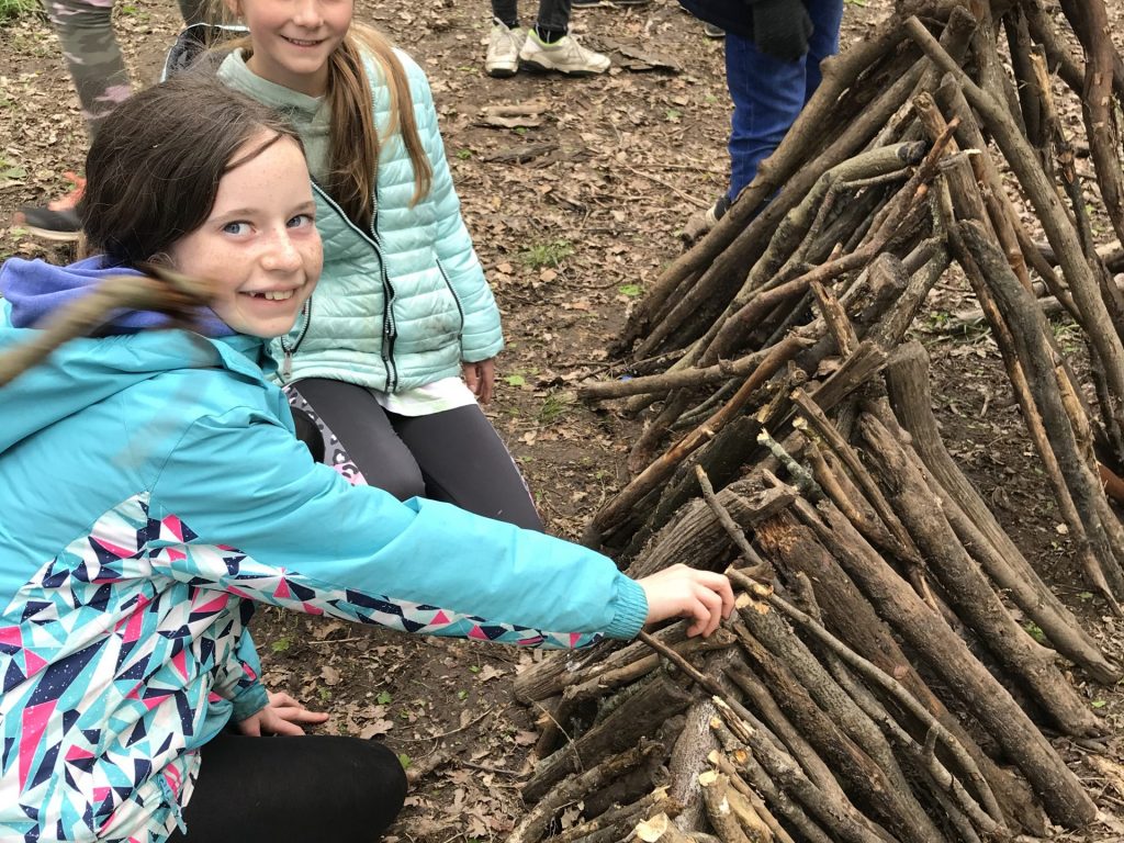 Children building a wooden den with sticks