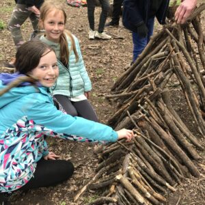 Children building a wooden den with sticks